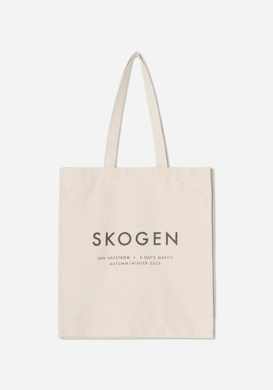 Naturvit tygkasse med texten SKOGEN i stora grå versaler, och under den Jan Håfström × A Day’s March, Autumn/Winter 2025.