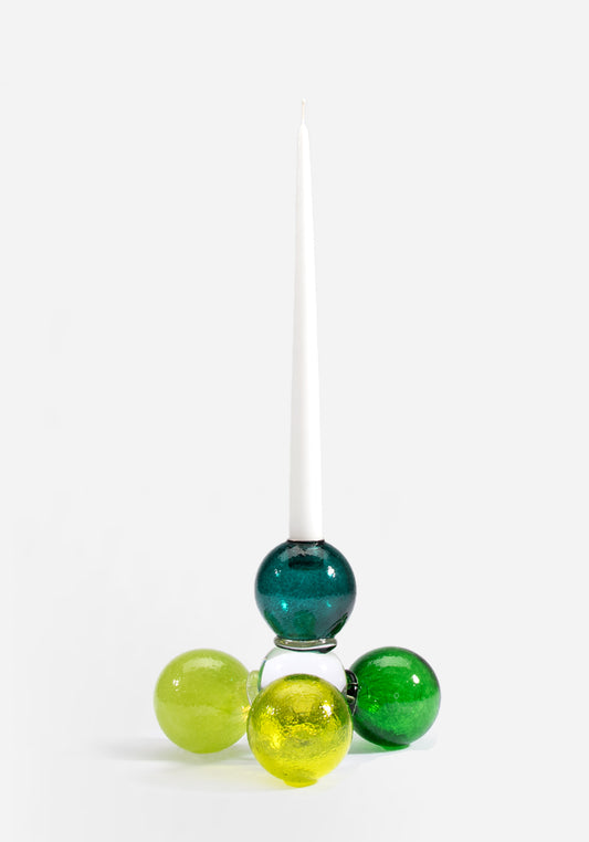 Munblåst ljusstake i glas av Åsa Gårdebäck, uppbyggd av färgglada glasbollar i gröna och gula toner. En lekfull ljusstake med mycket karaktär.