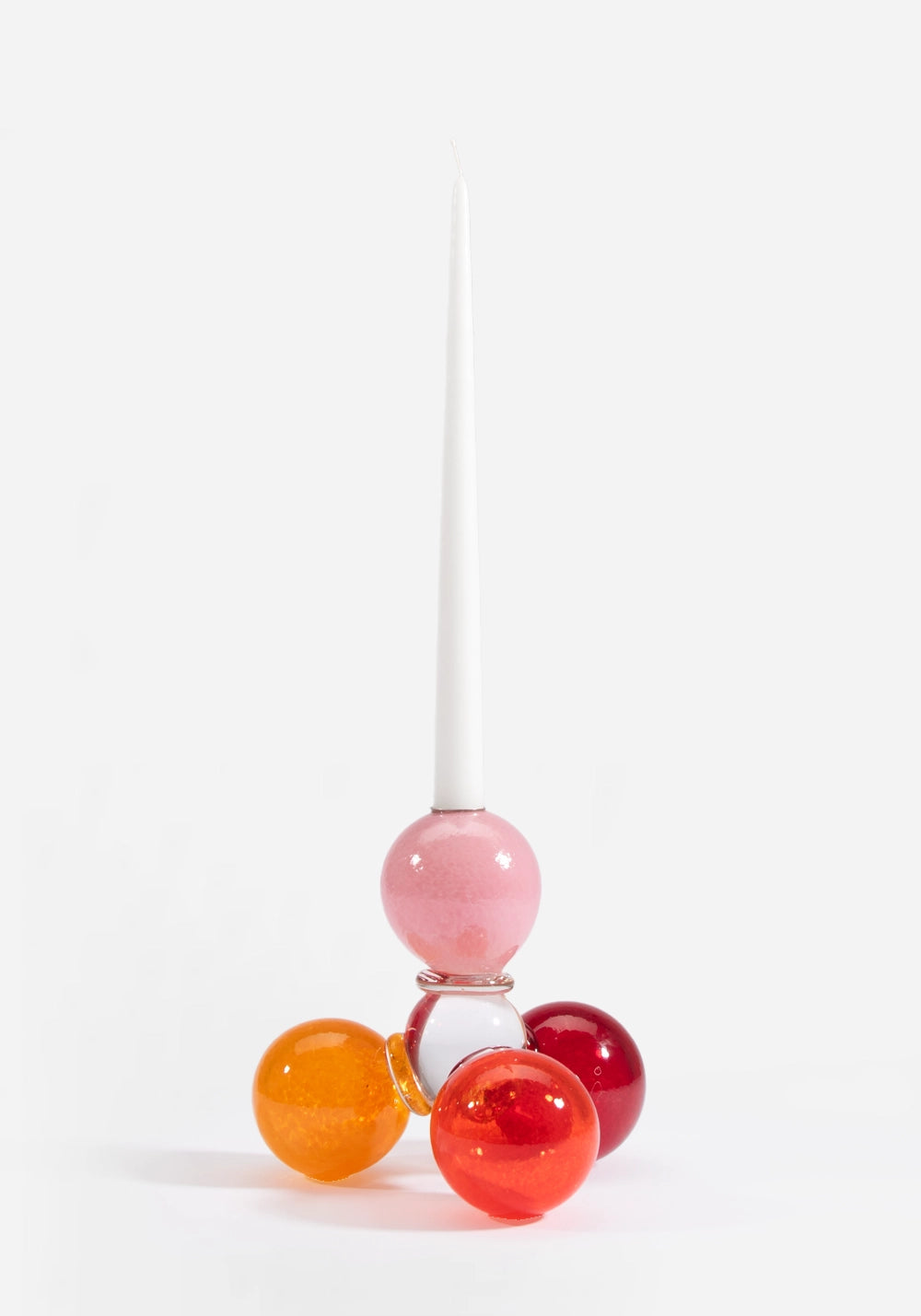 Munblåst ljusstake i glas av Åsa Gårdebäck, uppbyggd av färgglada glasbollar i rosa, röda och orangea toner med ett stearinljus i.