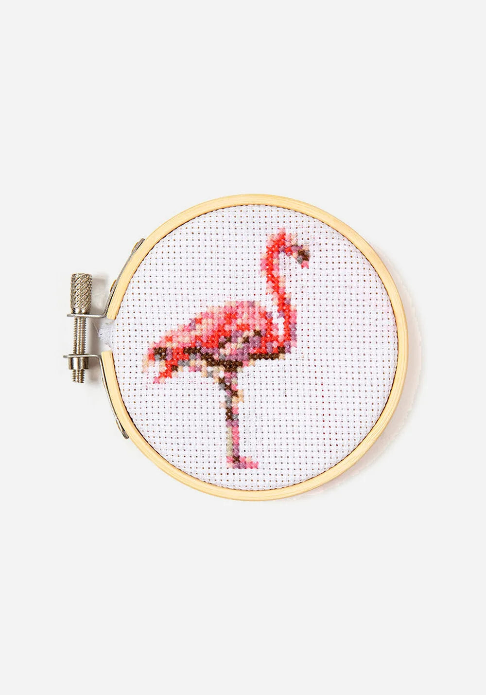 Färdigt korsstygnsbroderi i en broderiram i bambu, med en rosa och korallröd flamingo som står på ett ben.