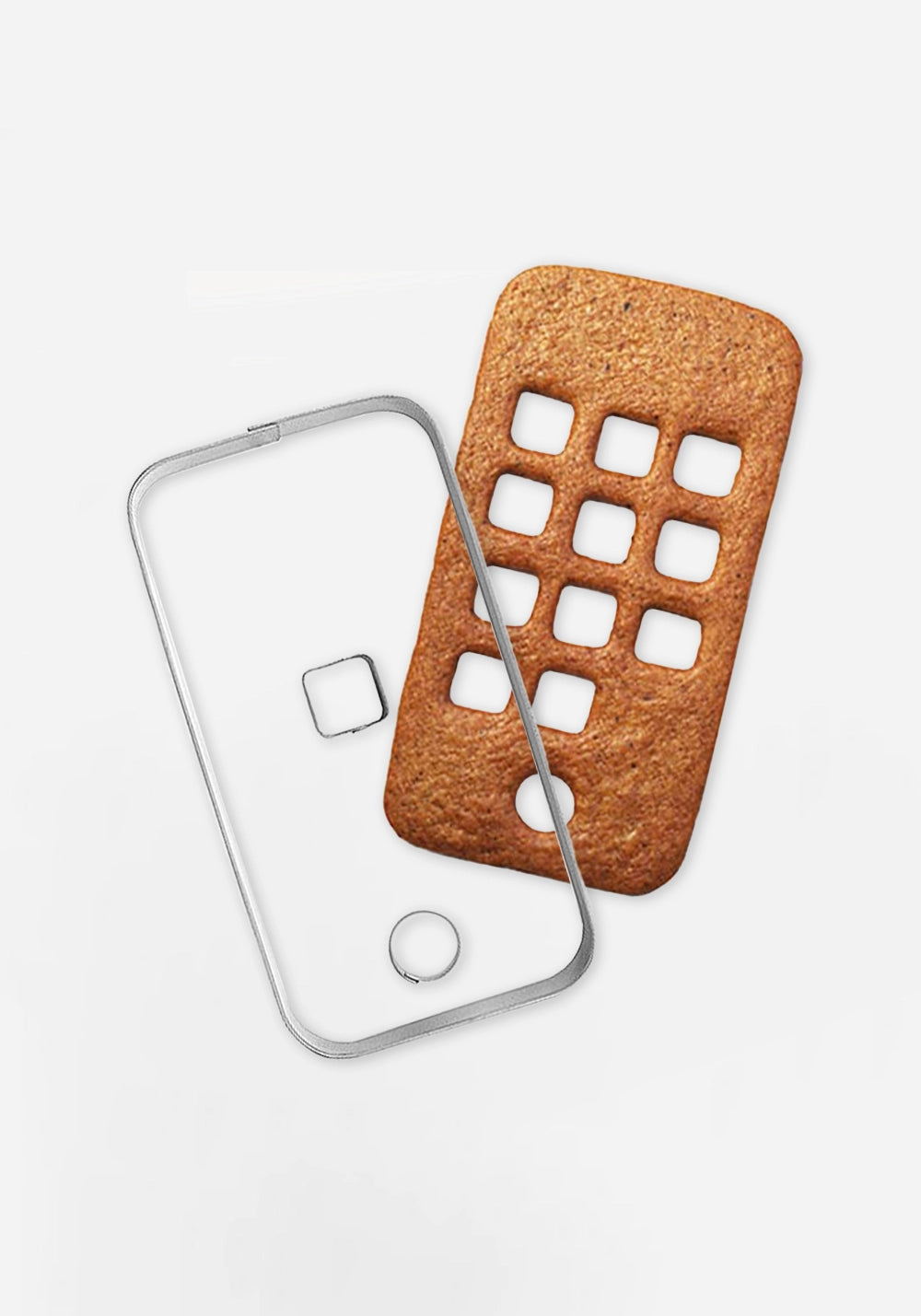 Pepparkaksform i rostfritt stål formad som en mobiltelefon, bredvid en gräddad pepparkaka med urstansade fyrkantiga appar och en rund knapp.