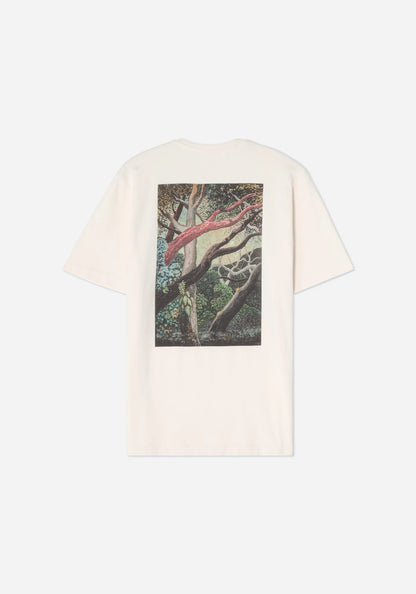 Baksidan av en benvit t-shirt med ett stort tryck av Jan Håfströms målning Skogen, med slingrande grenar i rödbrunt och grått i en grön skog.