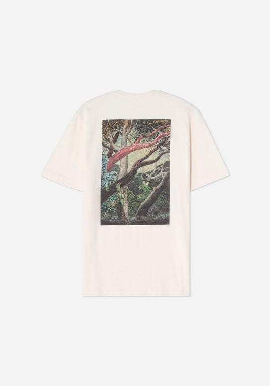 Baksidan av en benvit t-shirt med ett stort tryck av Jan Håfströms målning Skogen, med slingrande grenar i rödbrunt och grått i en grön skog.