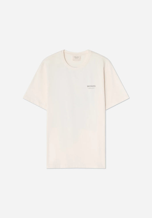 Benvit t-shirt med texten SKOGEN i små svarta versaler på bröstet.