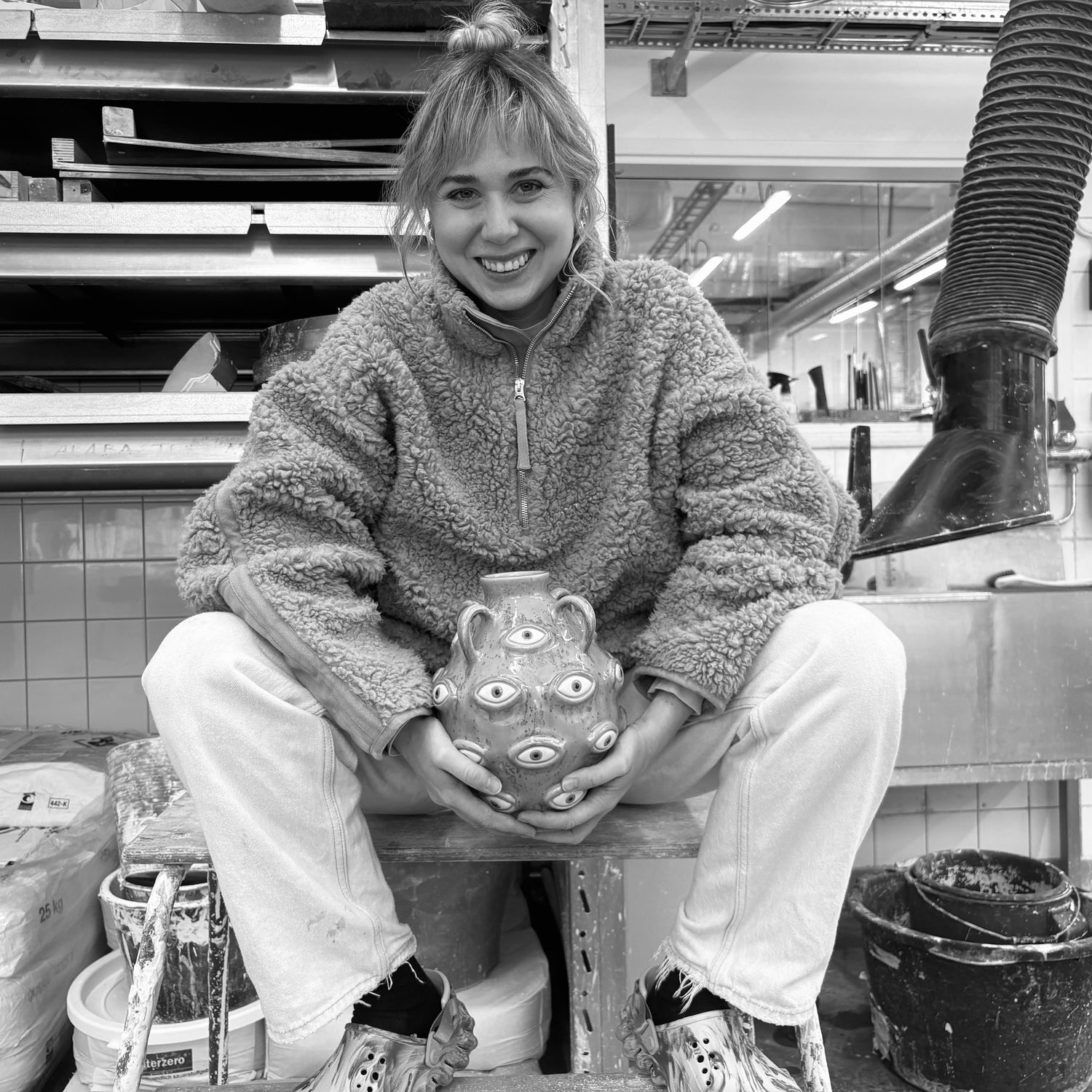 Bild på Nathalie Hallman från Studio Giallo där hon visar upp en vas i keramik dekorerad med hennes karaktäristiska ögon.